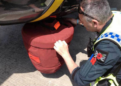 Helicopter camera cover being fitted by a British policeman
