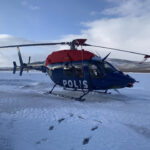 Bell 429 helicopter of the Swedish Police with engine covers and tip socks, on snow-covered ground.