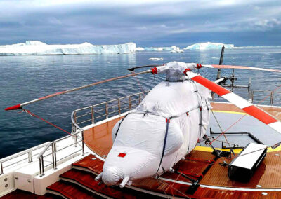 Bell 429 with a white full cover set on a yacht surrounded by ice glacier.